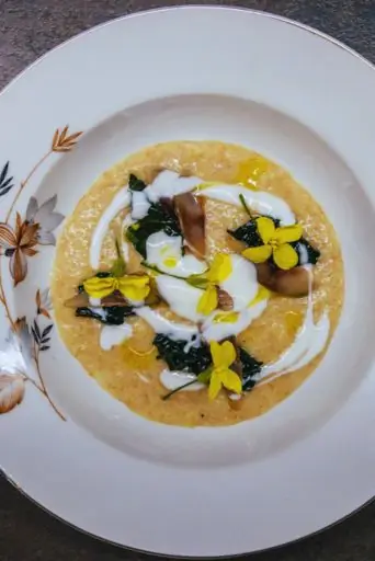 Chef sorridente con macchina della pasta