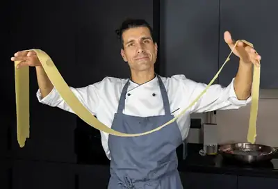 Private chef stretching pasta sheet